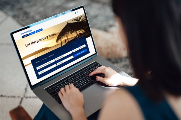 على المنظر الكتف لامرأة شابة تستخدم الكمبيوتر المحمول لحجز تذاكر الطيران وتخطيط العطلة (ألبوم الصور)