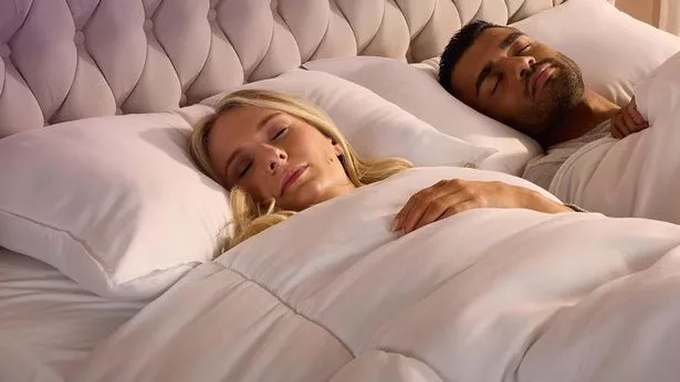 رجل وامرأة نائمان في السرير ينامان على الوسائد.