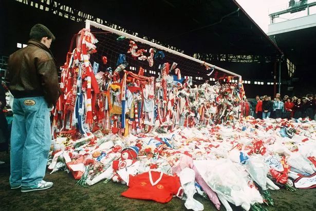 يقف أحد المعجبين في المرمى على أرض الملعب في Anfield ، مغطى بآلاف من عناقيد الزهور التي وضعت كعلامة على الاحترام للعديد من مشجعي ليفربول الذين فقدوا حياتهم في هيلزبورو