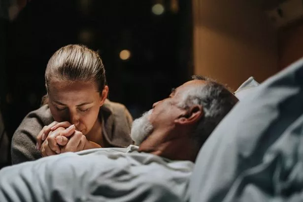 ابنة تقبيل على يد الأب مستلقيا في المستشفى