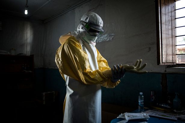 يضع عامل صحي على معدات الحماية الشخصية (PPE) قبل دخول المنطقة الحمراء لمركز أطباء بلا حدود (أطباء بدون الطيور) مركز علاج الإيبولا (ETC) ، حيث سيقوم بفحص المرضى في 6 نوفمبر 2018 في بونيا ، جمهورية الديمقراطية في كونغو