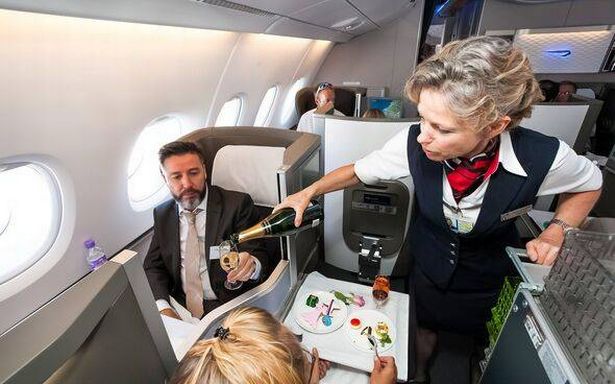 طاقم المقصورة الإناث يصب كوبًا من الشمبانيا في درجة الأعمال من Airbus A380