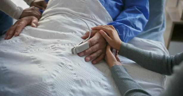 تمسك اليدين والمريض والعائلة عن طريق سرير المستشفى للحصول على الدعم والمرض والتعاطف من أجل العافية. الناس والرعاية ووحدة التحكم للشخص الذي يعاني من الاتصال والحب والمساعدة في الراحة من أجل الانتعاش في العيادة