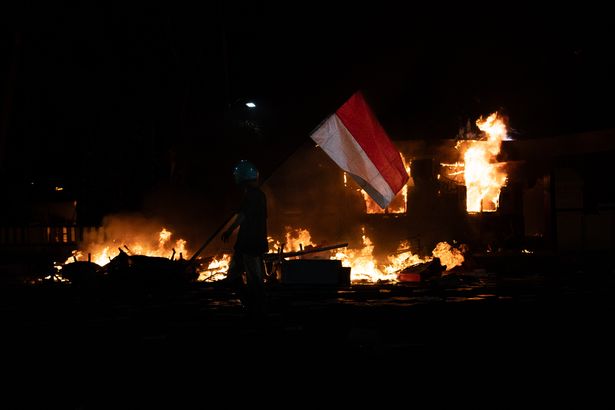 متظاهر المشي أمام مبنى مكتب الشرطة في قطاع تيغالساري سورابايا