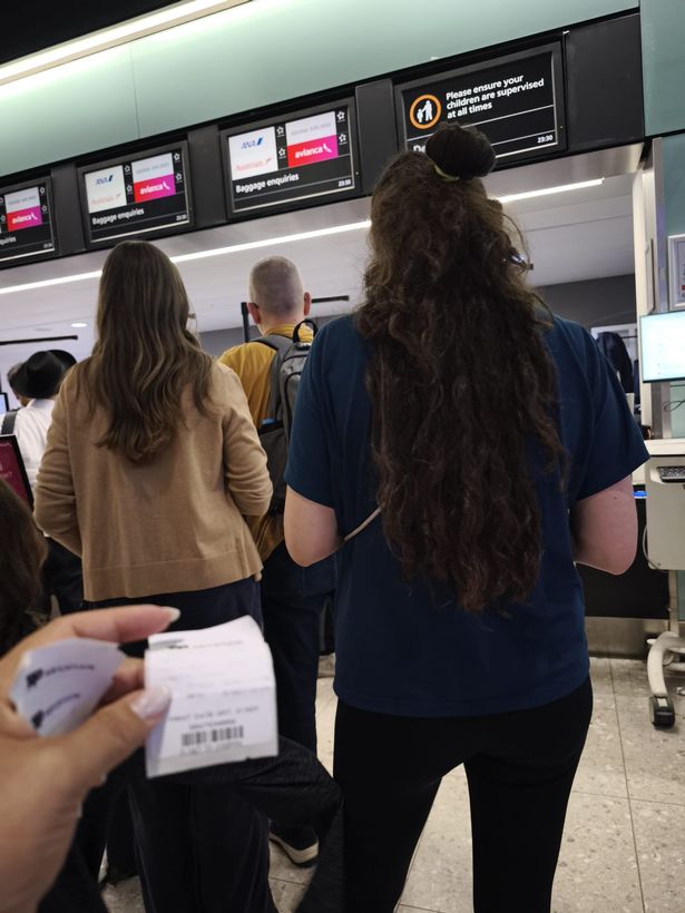 بيانكا بيري يحمل علامات أمتعة الأسرة أثناء طابور في استفسارات الأمتعة في المطار.