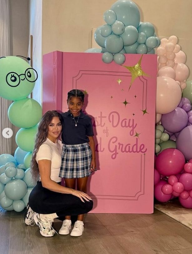 Khloe Kardashian وابنتها True متظاهرين بجانب البالونات وكتاب عملاق.