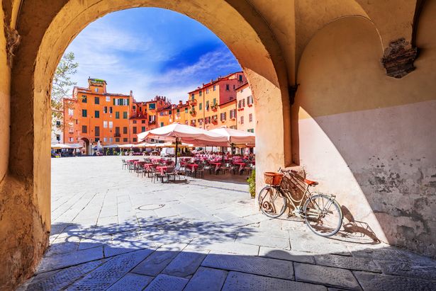   منظر لمربع Piazza Dell'Anfiteatro عبر القوس ، مدرج الإمبراطورية الرومانية القديم ، توسكانا الشهير.
