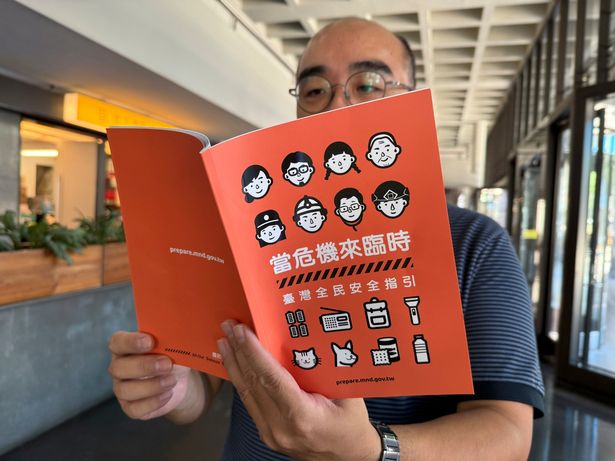 رجل يحمل كتيب دفاع مدني جديد