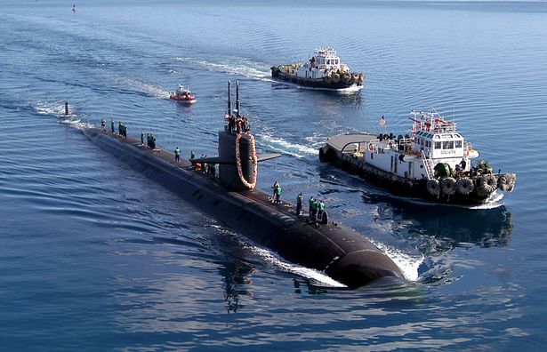 USS San Francisco (SSN 711) يجري مرافقتها من قبل اثنين من قاطرة الميناء إلى ميناء Apra ، غوام ، بعد نشر خمسة أشهر