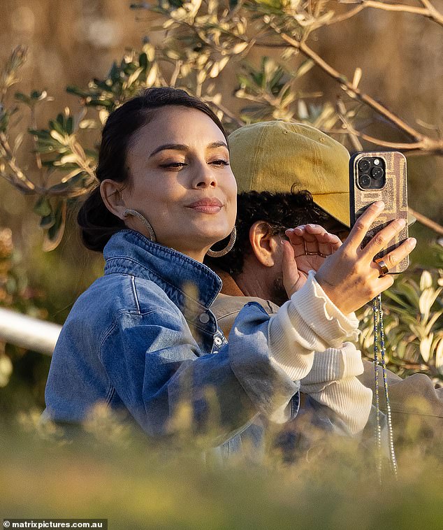 انتظر تومر بصبر بينما كانت النجمة الأسرة - التي كانت ترتدي الدنيم المزدوج ومسك حقيبة حمل منسوجة - أخذت صور سيلفي لأتباعها البالغ 1.4 ملايين