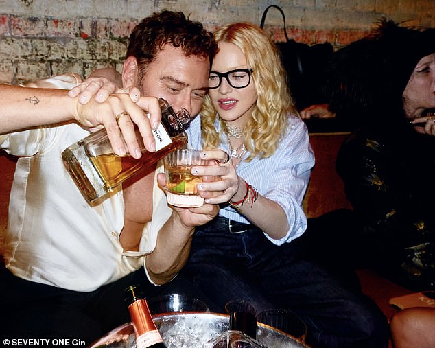 في هذه الأثناء ، قطعت مادونا شخصية أنيقة في قميص مخطط أزرق وبنطلون جينز داكن بينما سكبها صديقتها ميرت خلقًا مخصصًا لسبعين جين