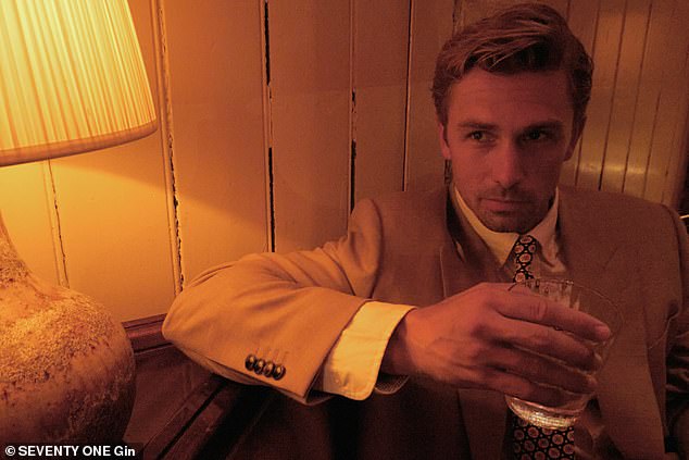 تحول عارضة الأزياء جيمس الرؤوس في بدلة بيج حادة ، وضرب الكاميرا مع مشروبه