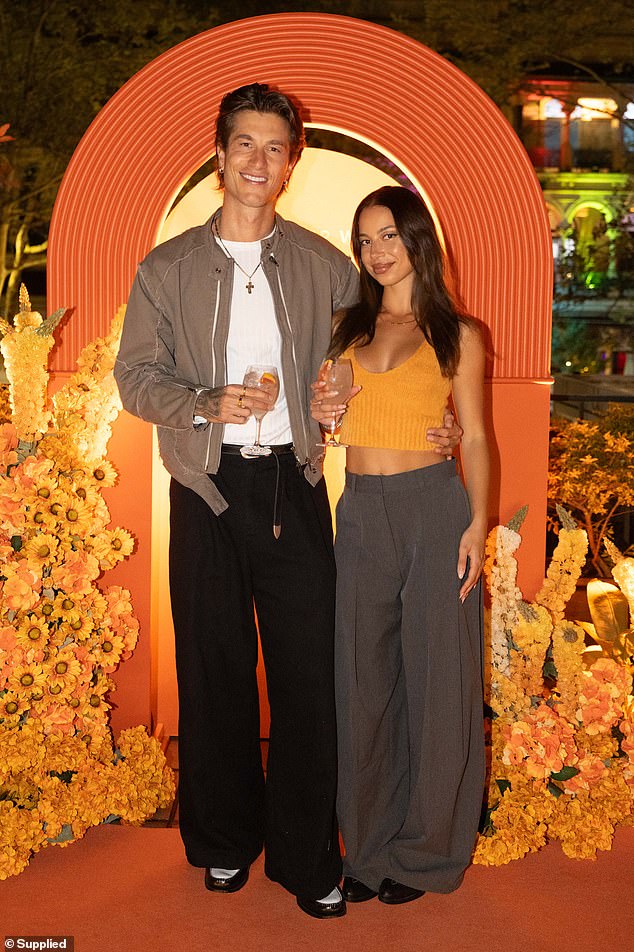 طراز مبارك وراثيًا جوش كارول أبقى الأمور غير رسمية ولكنه أنيقة في سترة قاذفة رمادية فاتحة طبقة على تي شيرت بيضاء ، مقترنة بنطلون سوداء فضفاضة وأحذية سوداء