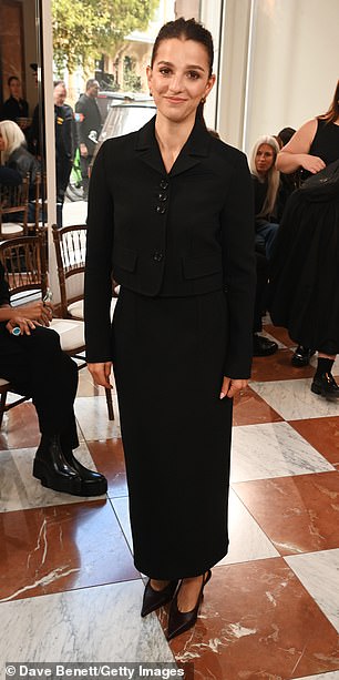 وأضافت أنيقة من الخناجر السوداء وحقيبة مصغرة من الجلد الأنيقة أثناء قيامها بتشكيل لقطات رائعة في حدث الموضة