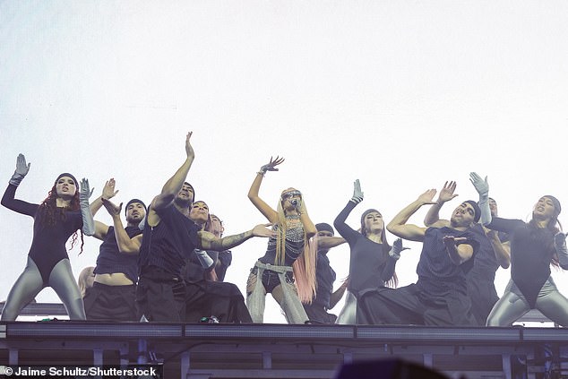 كان عدد الجلود المفعم بالحيوية مرصعة بالسلاسل الفضية والخرز ، في حين أنهى النجمة مظهرها من القفازات بدون إصبع ، وجوارب شباك السمك والظلال الملونة