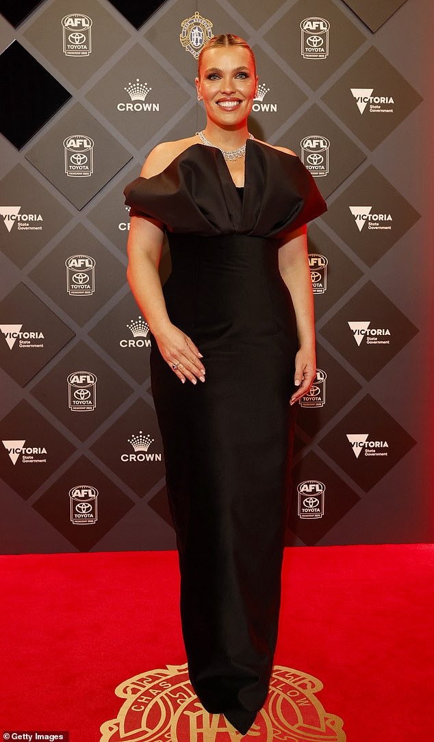 كان لاعب كرة القدم ومقدم تلفزيون Abbey Holmes أنيقة باللون الأسود ، واختار ثوبًا جلس بالقرب من شخصيتها وكان لديه تفاصيل القوس الساتان عند التمثال