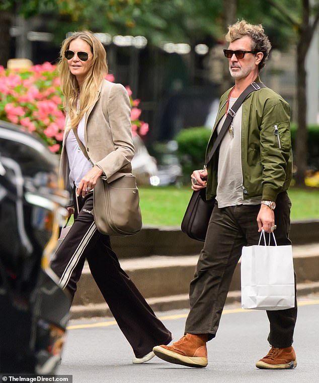 بدت Elle أنيقة في نزهة التسوق في سروال المسار الأسود ، وقميص أبيض وليزر البيج