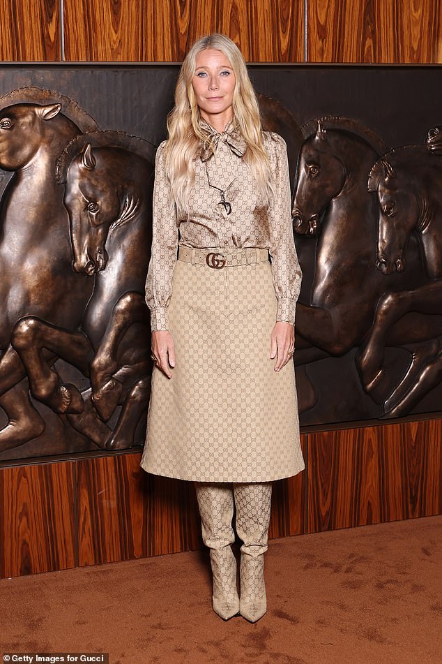 يتألف الزي من قميص ساتان وتنورة ميدي وأحذية عالية الركبة