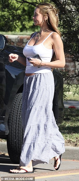 قامت بإقران المفرد الذي يعانق الشكل مع تنورة القماش القطني الزرقاء والأبيض