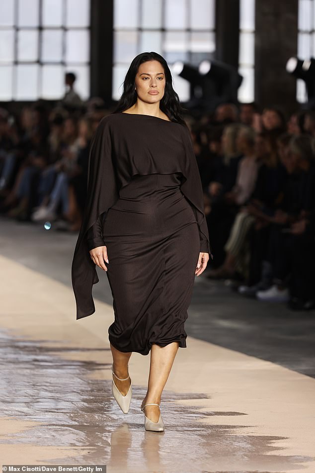 انتقل عارضة الأزياء آشلي جراهام إلى المدرج أثناء العرض واجتقى باهتمام في ثوب ميدي بني غامق وكعوب بيضاء