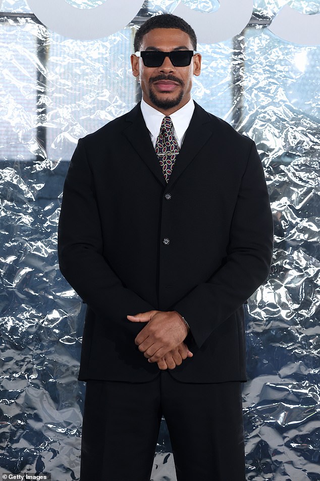 كان آرون بيير يرتدي بدلة سوداء مع قميص أبيض وربطة عنق مزخرفة