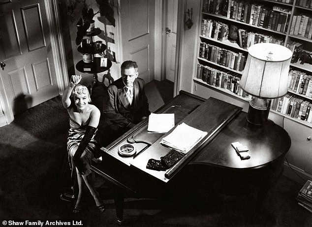 جالس مونرو في بيانو مع النجمة المشاركة توم إيويل بينما كانت تلوح بكاميرا شو أثناء التصوير لمدة سبع سنوات في عام 1954