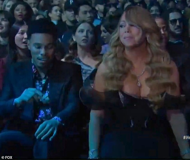 ومع ذلك ، في وقت من الأوقات عندما غنت لونغ ننتمي معًا - كانت الكاميرا قد قطعت لفترة وجيزة إلى كاري لأنها أدارت رأسها ببطء بعيدًا عن المسرح وأعطت نظرة جانبية على يمينها (كما هو موضح أعلاه)