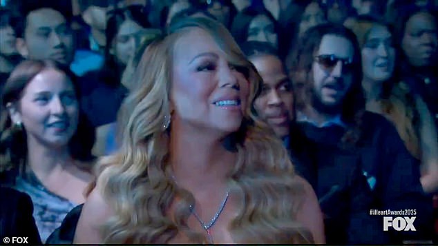 جنبا إلى جنب مع لمحة جانبية إلى يمينها ، أظهرت لحظة أخرى تم القبض عليها على الكاميرا كاري مع ابتسامة كبيرة على وجهها - والتي تلاشت ببطء مع استمرار الأداء