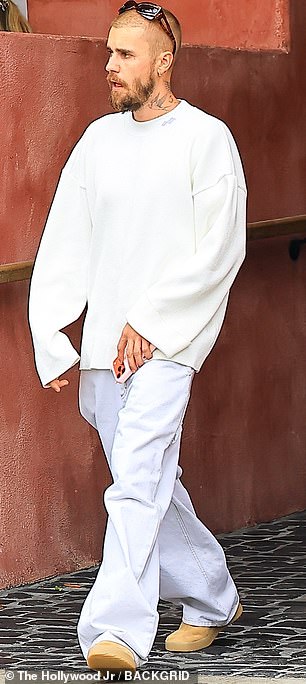 في هذه الأثناء ، كان جاستن يرتدي أحد ملابسه الفضفاضة المميزة ، وهذه المرة قميص كريم يتدفق على مجموعة من التعرق الرمادي اللؤلؤي