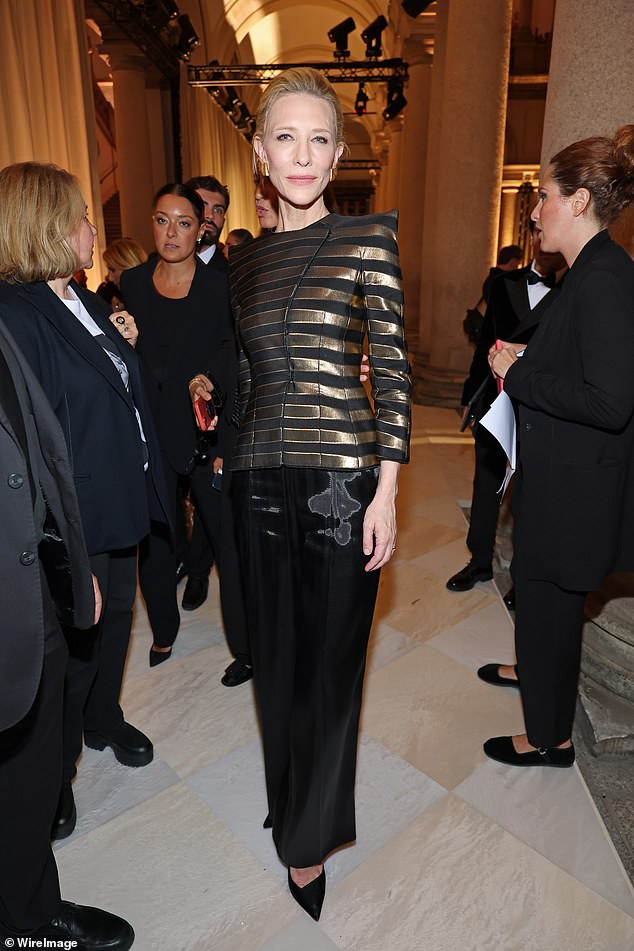 ارتدى كيت سترة سوداء وذهبية منظمة مع بنطلون عريض الساق