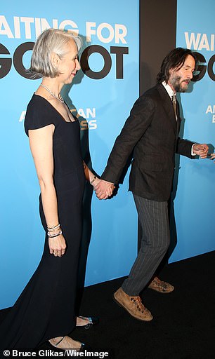 تم تنظيف Keanu في سترة أسود على قميص أبيض ، وفضة رقبة ، وسروال رمادي دبوس ، وأحذية المشي لمسافات طويلة بنية قذرة