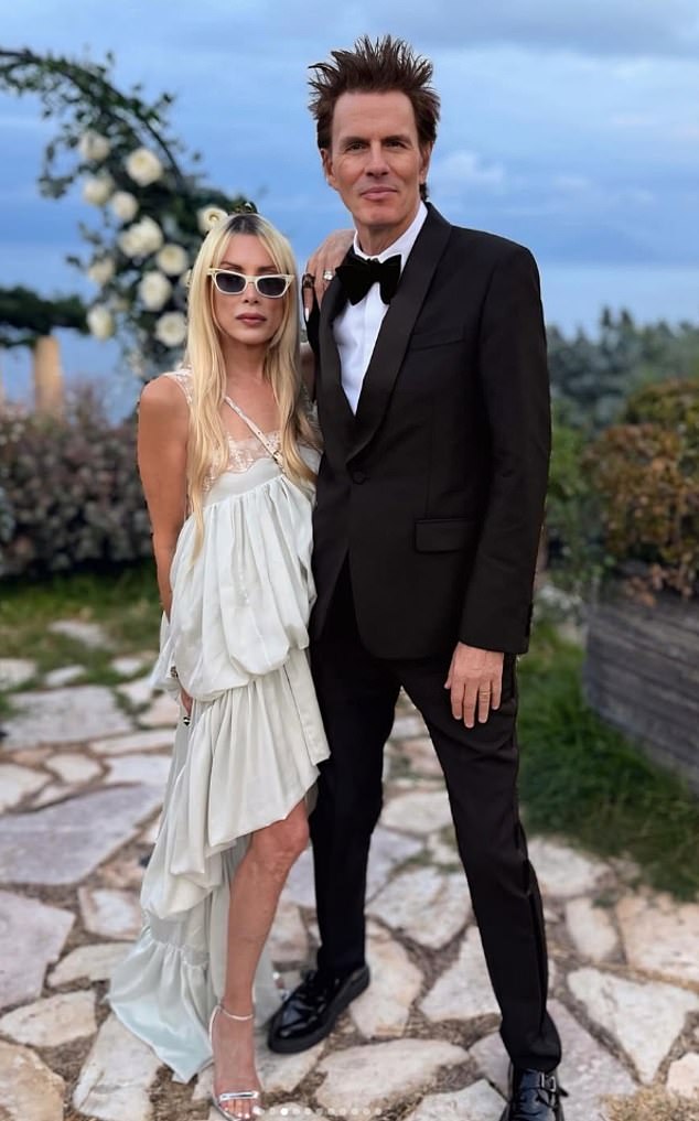 تم القبض على الممثلة السابقة جيلا ، التي تزوجت من جون في عام 1999 ، وتبدو جديدة بشكل مستحيل وهي تتظاهر بجوار زوجها في ثوب أبيض مجهز