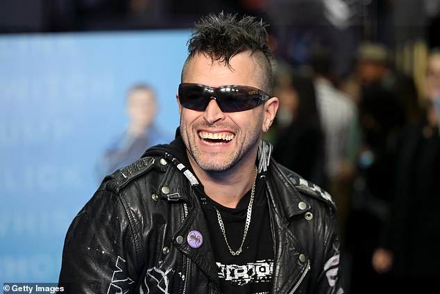 كان بيت في السجادة الحمراء من الفحص ، كان في أرواح عالية يرتدي سترة جلدية وعرض مجموعة واسعة من الوشم