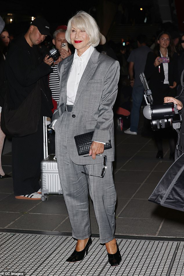 عرضت هيلين إحساسها الجهد بالأناقة في بدلة الرمادي الرمادي الأنيق وهي تشق طريقها إلى عرض ستيلا