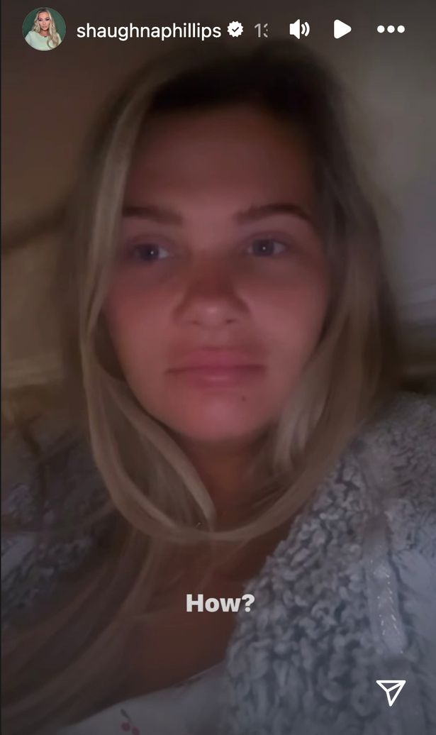Shaughna Phillips في قمة بيضاء وثوب خلع الملابس الأزرق يسجل رسالة فيديو.