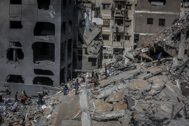 يبحث الفلسطينيون بين الأنقاض عن الأشياء القابلة للاستخدام بعد الهجمات الإسرائيلية في حي Rimal في مدينة غزة