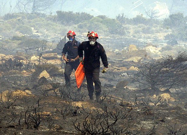 يحمل رجال الإطفاء نقالات من خلال حطام طائرة الخطوط الجوية Cypriot Helios التي تحمل 115 مسافرًا و 6 طاقم ، تحطمت في الجبال بالقرب من Grammatiko على بعد حوالي 45 كم من أثينا 14 أغسطس 2005 ، لم يتم العثور على أي ناجين. 