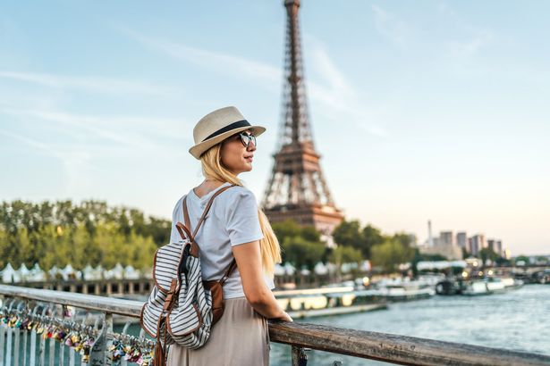 امرأة سياحية شابة تستمتع أمام برج إيفل ونهر نهر السين في باريس ، فرنسا. ألبوم الصور.