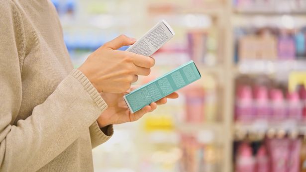 امرأة تحقق من منتج التجميل