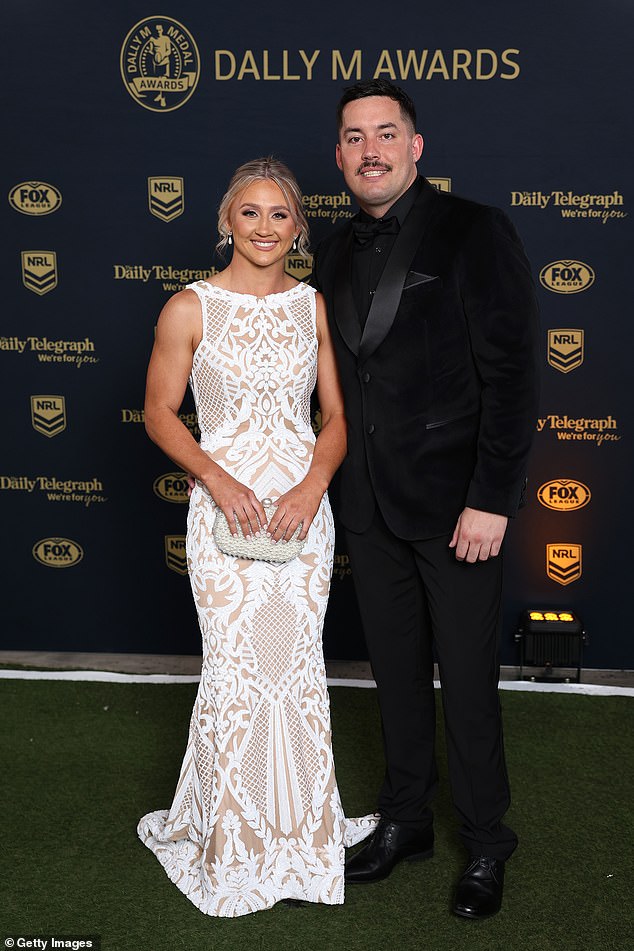 وصلت لاعب كوينزلاند رعاة البقر إيما مانزلان على ذراع هايدن بيلي ووقفت من الحزمة في ثوب دانتيل أبيض