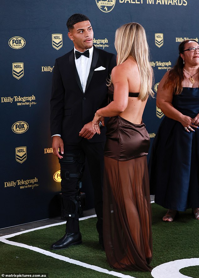 كانت إيندي وميضًا من اللحم في ثوبها البني ، والذي يتميز بالتجزئة الشفافة وقصص في الحجاب الوسط