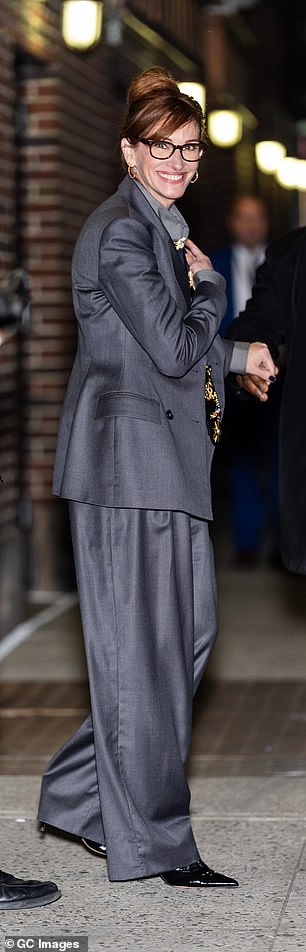 تم إقران السترة مع قميص فستان رمادي وسروال عالي مخصر مع الطيات