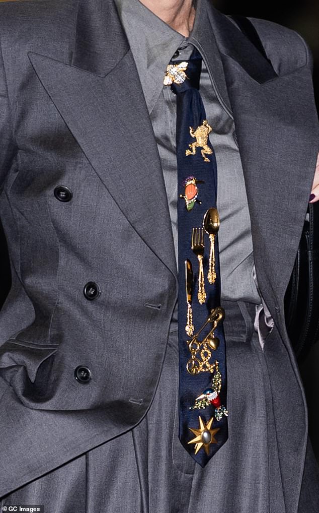 قام النجم بتجميع المظهر مع ربطة عنق البحرية المذهلة التي تم إكسسواراتها بشكل كبير مع الدبابيس ودبابيس ، بما في ذلك الضفدع الذهبي والطيور والذهبية