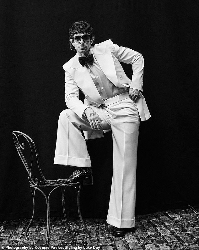 أظهر النجم لاحقًا جانبه اللطيف في بدلة رسمية بيضاء ناصعة مقترنة بنظارات شمسية كبيرة الحجم وحذاء أسود مزخرف بينما كان يقف على كرسي الشرفة