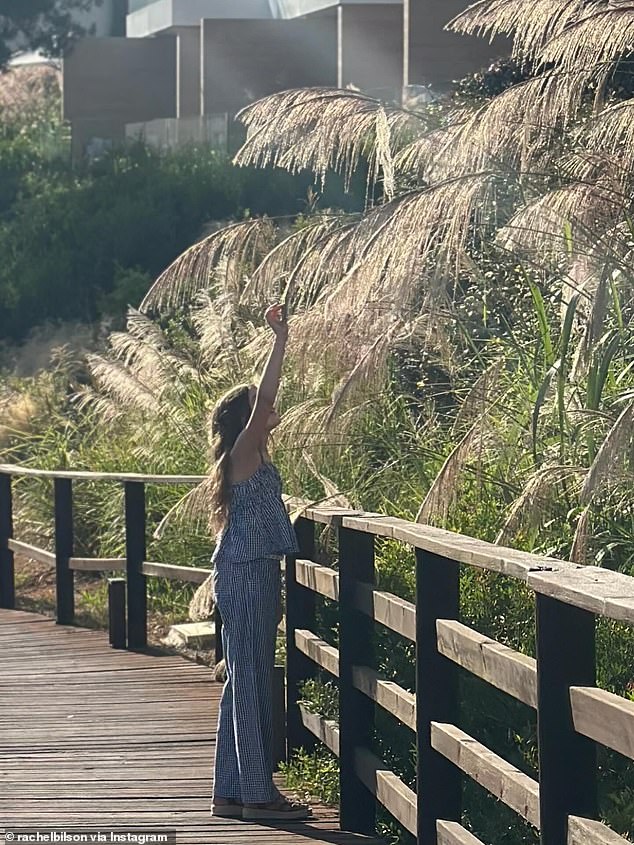 وفي الصورة، ارتدت ابنتها المراهقة قميصًا صيفيًا مخططًا ومجموعة سروال، وشوهدت وهي تمد ذراعها فوق رأسها، وأمام وجهها، لأوراق شجرة.