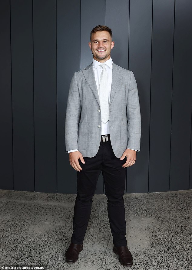 تم تنظيف نجم NRL Jake Simpkin جيدًا في معطف رياضي رمادي فاتح وسروال أسود