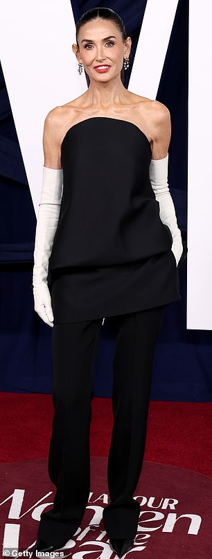 انزلقت صفارة الإنذار البالغة من العمر 62 عامًا إلى قمة منظمة بدون حمالات تصل إلى منتصف الفخذ مثل سترة، بنفس لون بنطالها المجهز.