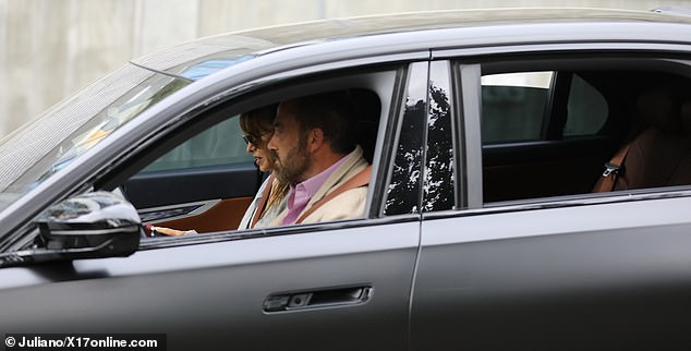 برز أحمر شفاهها الأحمر الداكن على بشرة مشرقة محاطة بستائر من الشعر الحريري الداكن، مع تساقط هامش على نظارتها الشمسية اللامعة الكبيرة.