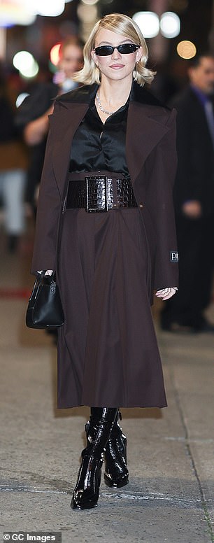 كانت ترتدي بلوزة حريرية سوداء تحت سترة بورجوندي كبيرة وتنورة عالية الخصر