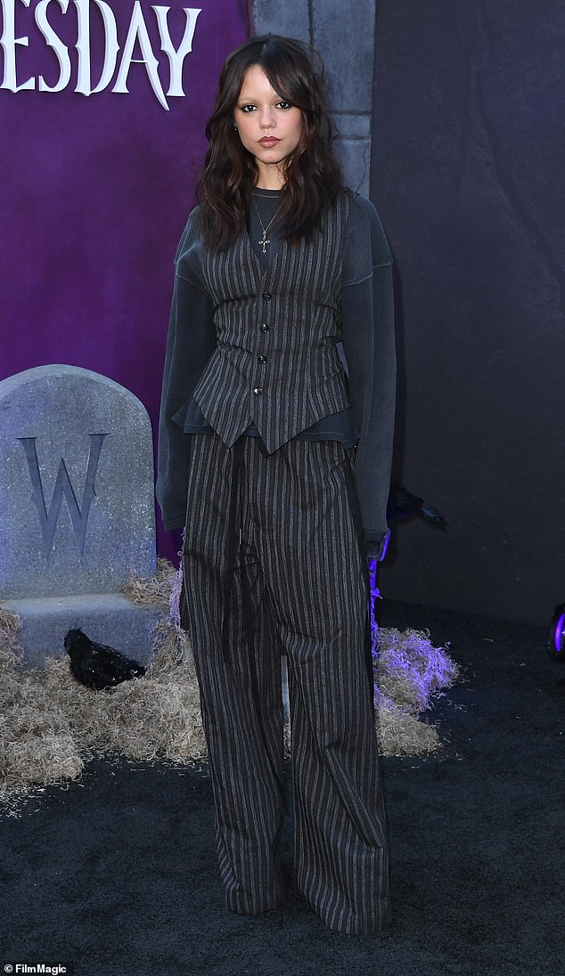 وصلت جينا مرتديةً تنسيقًا باللونين الرمادي والأسود يتكون من سترة وسروال